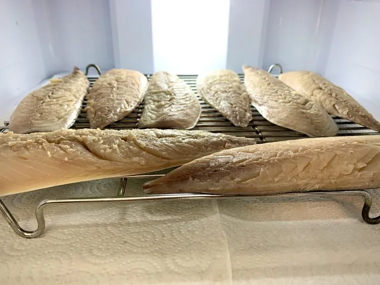 Mackerel fillets skin side down on a wire rack in the fridge