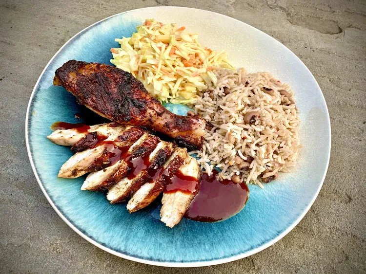 Smoked jerk chicken, carved, with rice and peas, pineapple coleslaw and jerk BBQ sauce