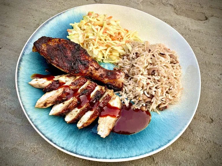 Smoked jerk chicken, carved, with rice and peas, pineapple coleslaw and jerk BBQ sauce