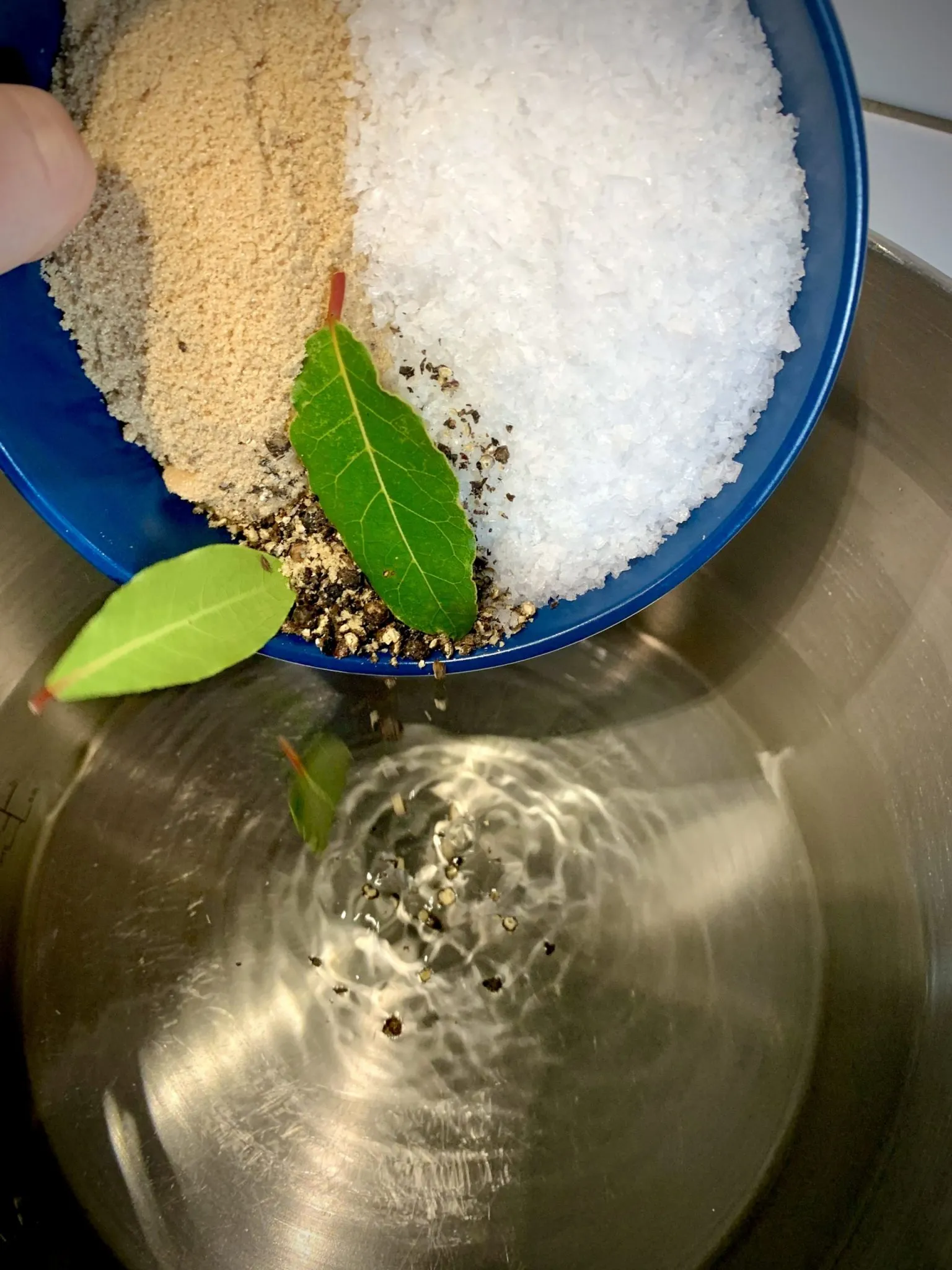 Salt, brown sugar and pepper tipped from a bowl into a pot for a turkey brine